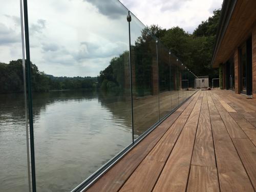 frameless with glass connectors on decking by lake by Balcony Installations